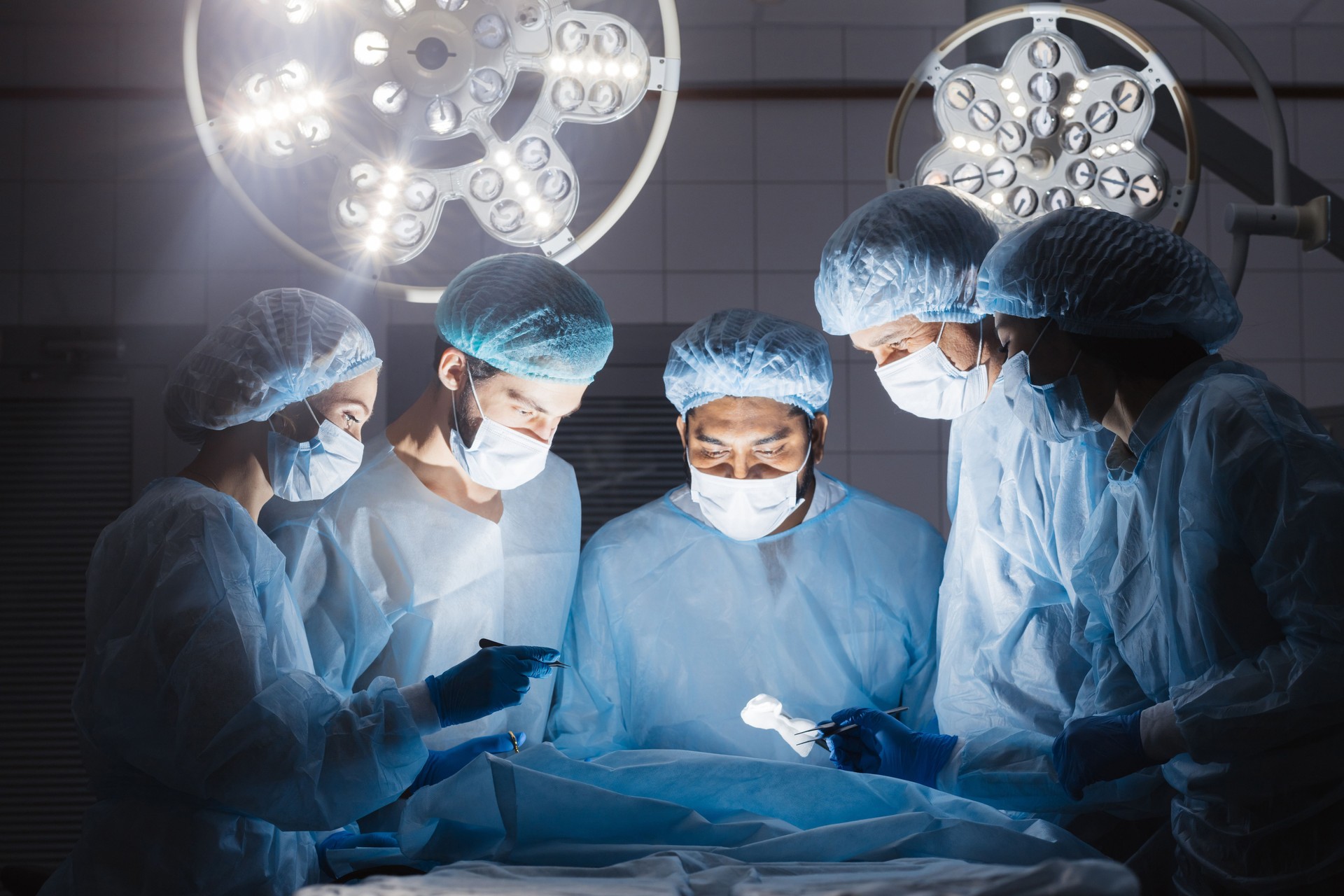 Doctors team in surgery in a dark background